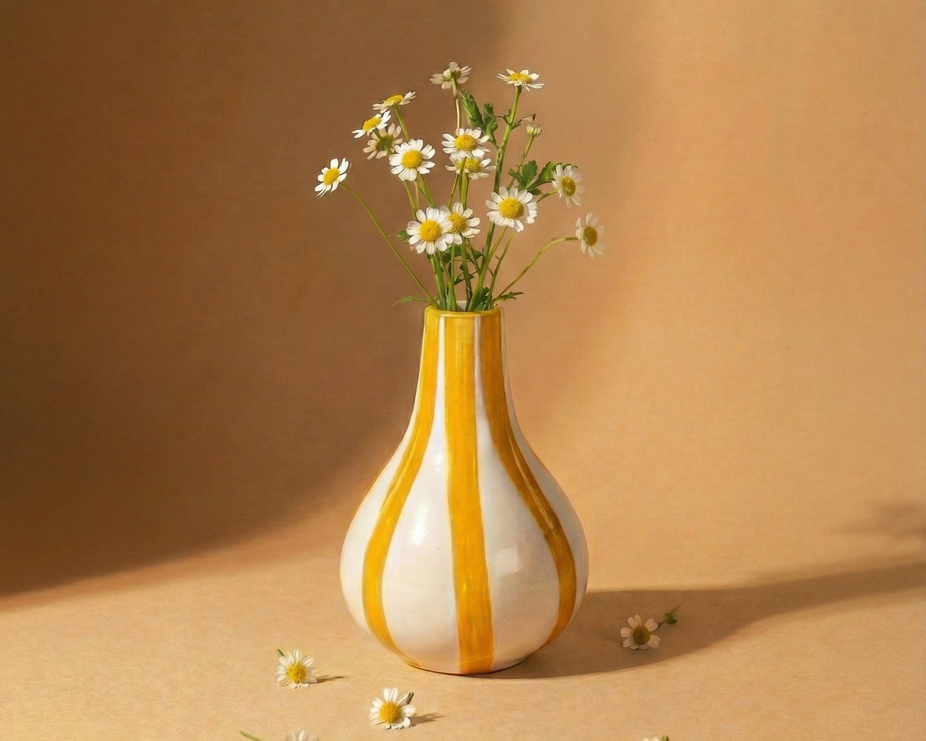 Vase with striped pattern containing flowers on a beige background