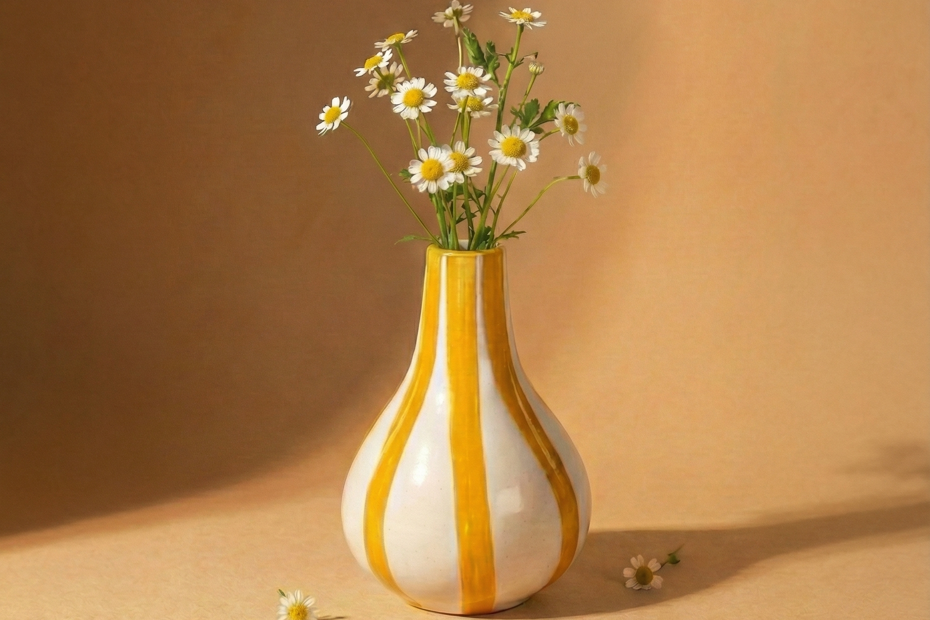 Vase with striped pattern containing flowers on a beige background
